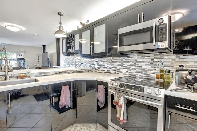 kitchen with backsplash, pendant lighting, stainless steel appliances, and sink