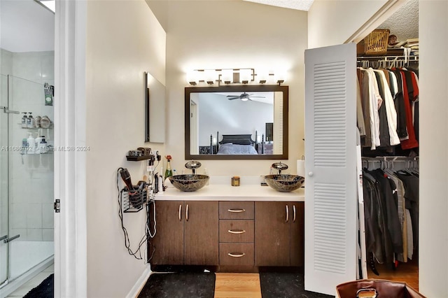 bathroom featuring hardwood / wood-style floors, vanity, a textured ceiling, and a shower with door