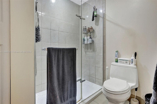 bathroom with tile patterned flooring, toilet, and a shower with shower door