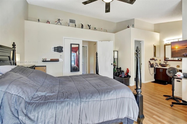 bedroom featuring a textured ceiling, ceiling fan, a spacious closet, light hardwood / wood-style floors, and a closet