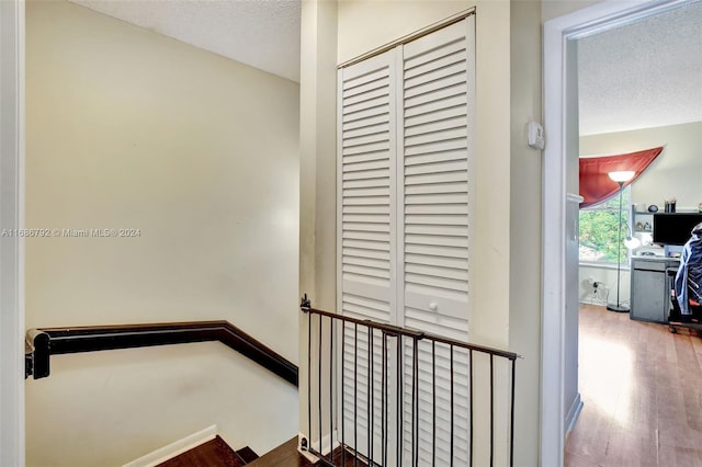 stairway featuring wood-type flooring and a textured ceiling