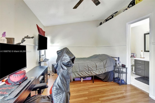 bedroom with a textured ceiling, light wood-type flooring, ceiling fan, and lofted ceiling