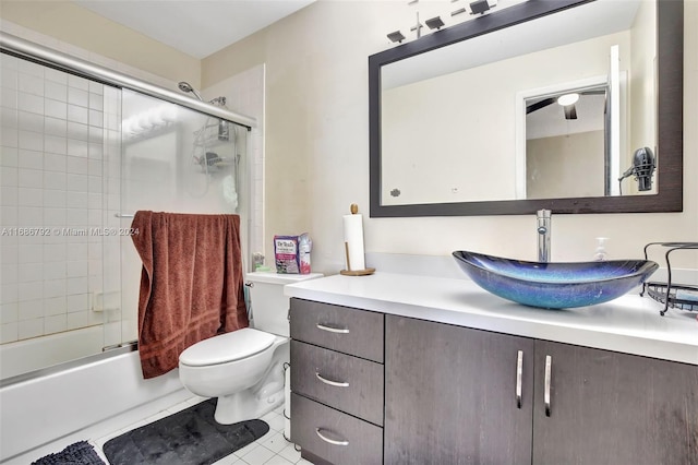 full bathroom with tile patterned floors, vanity, toilet, and enclosed tub / shower combo