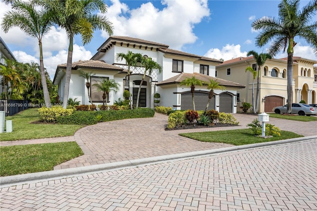 mediterranean / spanish-style house with a garage and a front lawn