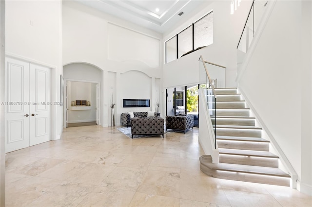 foyer entrance with a fireplace and a towering ceiling