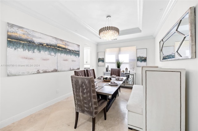 dining room featuring a tray ceiling, crown molding, and a notable chandelier