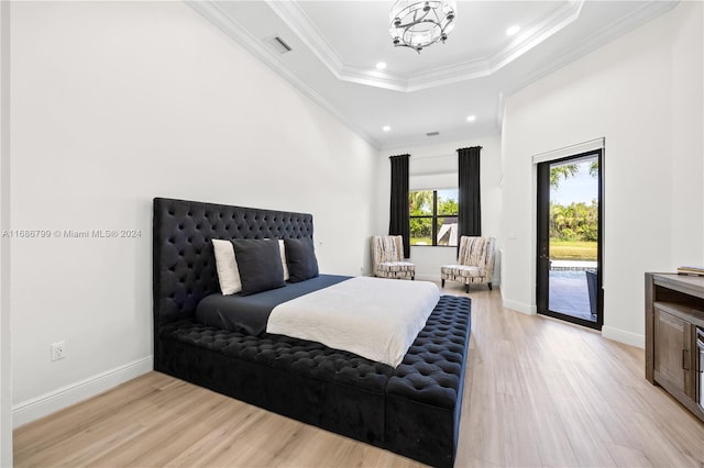 bedroom with ornamental molding, a raised ceiling, a notable chandelier, light wood-type flooring, and access to outside