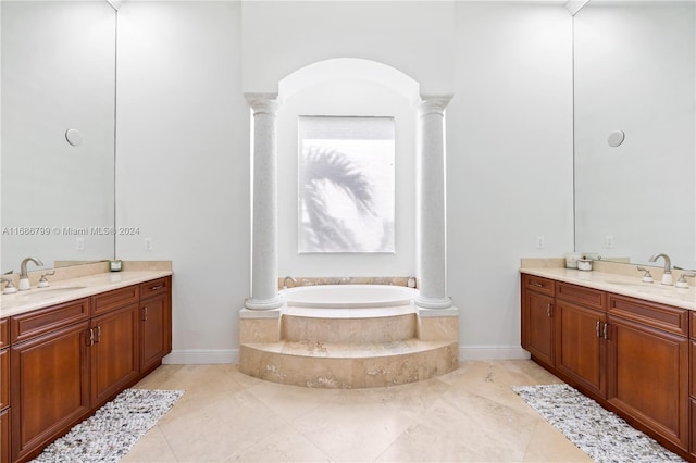 bathroom with vanity, a relaxing tiled tub, and tile patterned floors