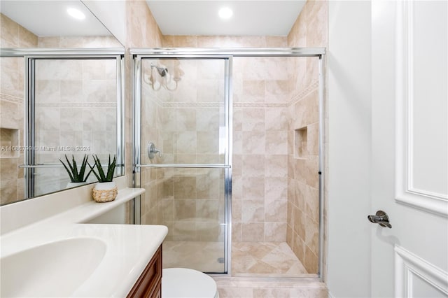 bathroom featuring walk in shower, vanity, and toilet