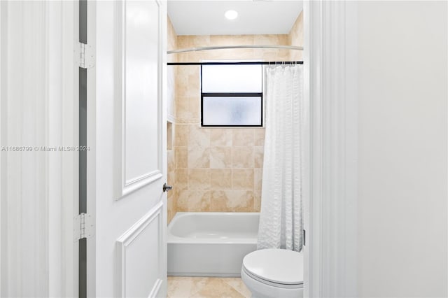 bathroom with shower / bath combo with shower curtain, tile patterned flooring, and toilet