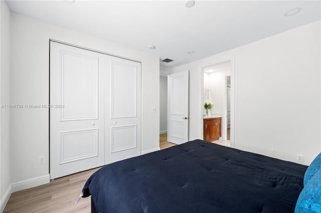 bedroom featuring connected bathroom, a closet, and light wood-type flooring