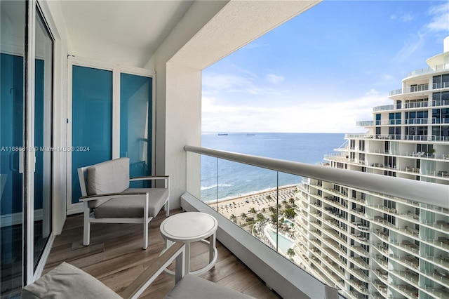 balcony featuring a water view and a beach view