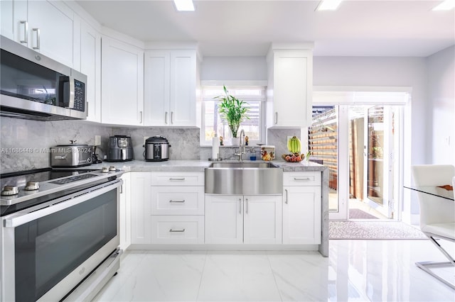 kitchen with white cabinetry, stainless steel appliances, and sink