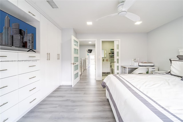 bedroom featuring light hardwood / wood-style flooring, ensuite bathroom, and ceiling fan