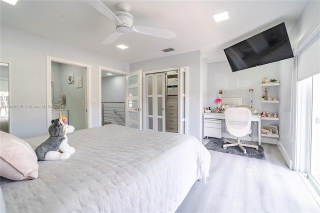 bedroom featuring a closet, ceiling fan, multiple windows, and hardwood / wood-style floors