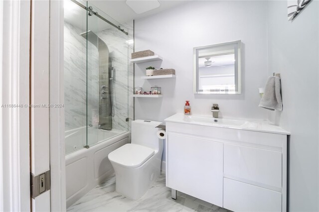 full bathroom featuring vanity, shower / bath combination with glass door, and toilet