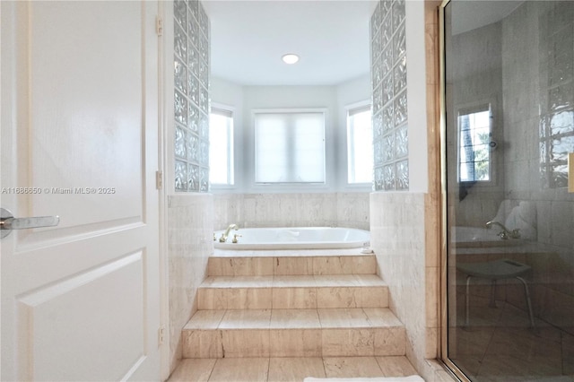 bathroom featuring independent shower and bath