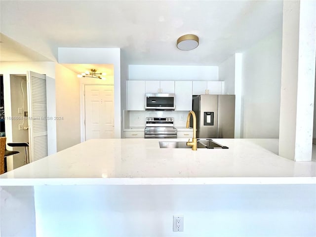 kitchen with sink, appliances with stainless steel finishes, and white cabinetry