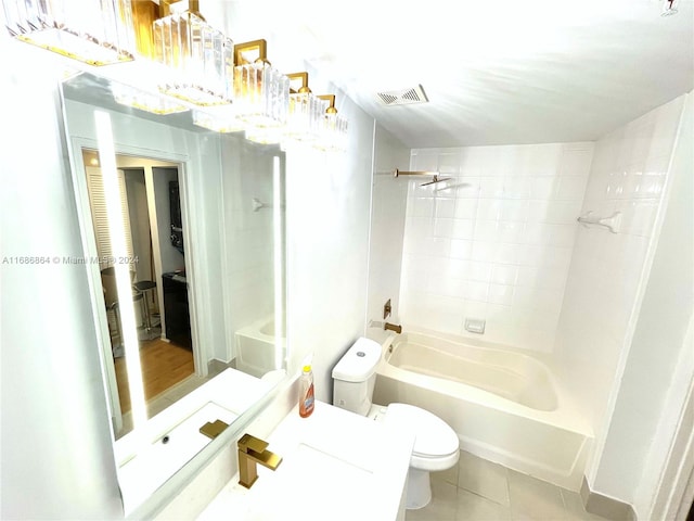 bathroom featuring toilet, tile patterned flooring, and tiled shower / bath