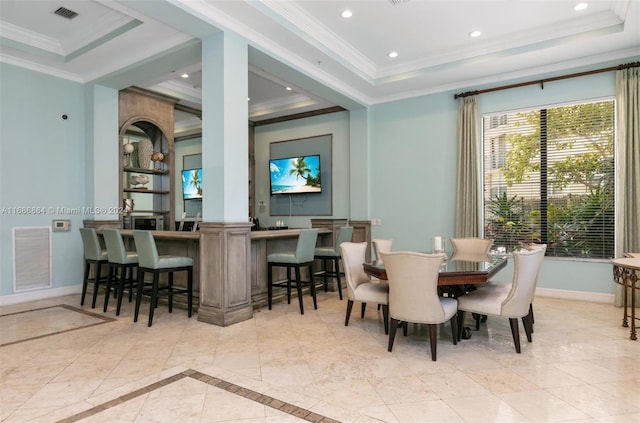 dining space featuring a raised ceiling and ornamental molding