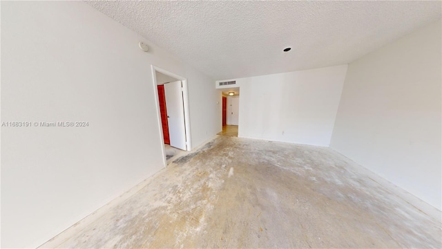 spare room with a textured ceiling