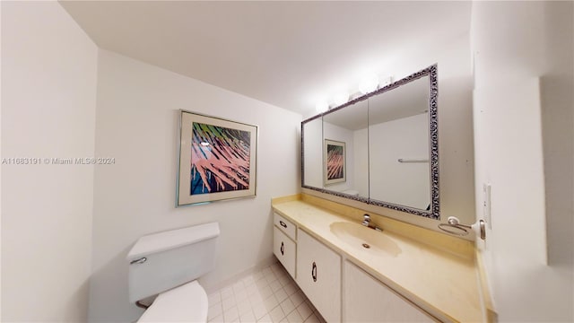 bathroom with vanity, toilet, and tile patterned flooring