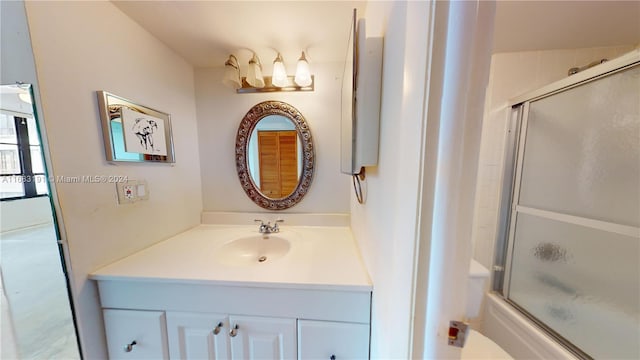 bathroom with vanity and combined bath / shower with glass door