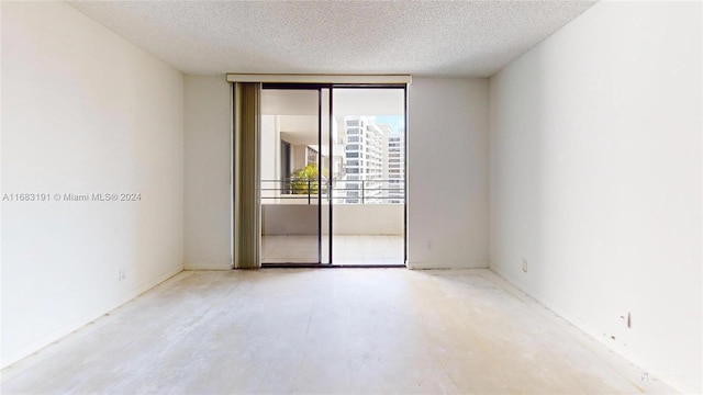 unfurnished room with a textured ceiling and expansive windows