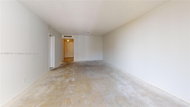 unfurnished room with a textured ceiling