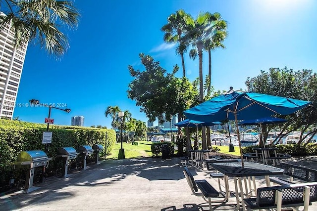 view of property's community featuring a patio and a lawn