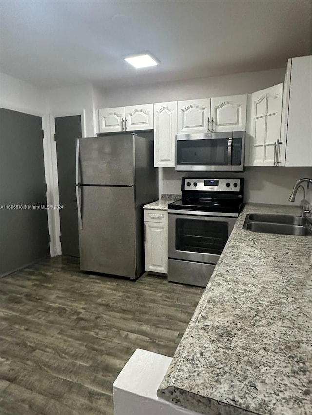 kitchen featuring sink, appliances with stainless steel finishes, dark hardwood / wood-style floors, and white cabinetry