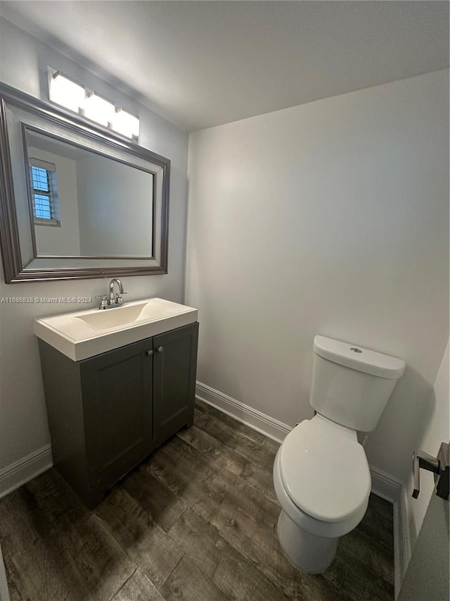 bathroom with vanity, hardwood / wood-style flooring, and toilet