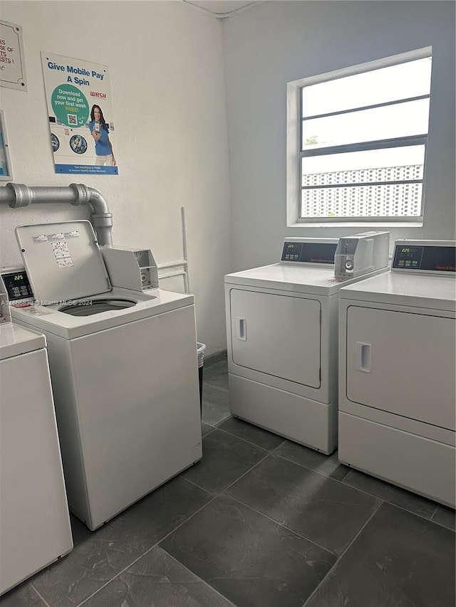 washroom with dark tile patterned floors and washing machine and clothes dryer