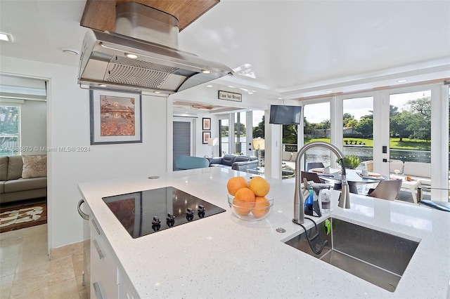 6616 E Miami Lakes Dr E, Miami Lakes, FL 33014 - kitchen featuring black electric stovetop, open floor plan, light stone countertops, island exhaust hood, and french doors