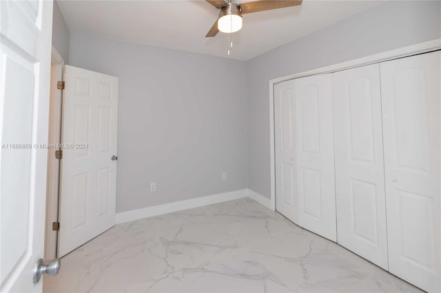 unfurnished bedroom featuring ceiling fan and a closet