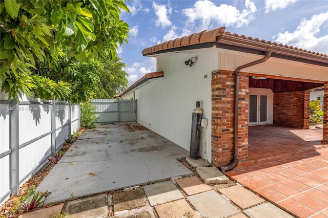 view of side of home featuring a patio area and french doors