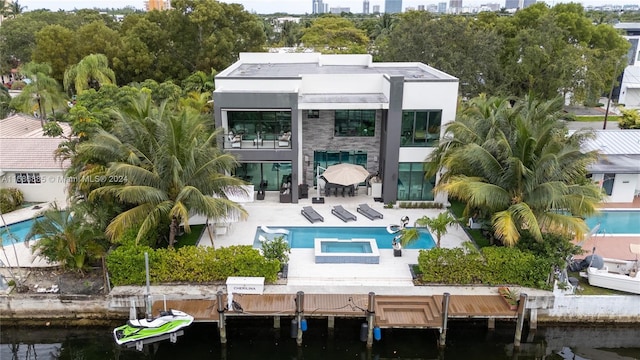 back of house with a balcony, a patio, and a water view