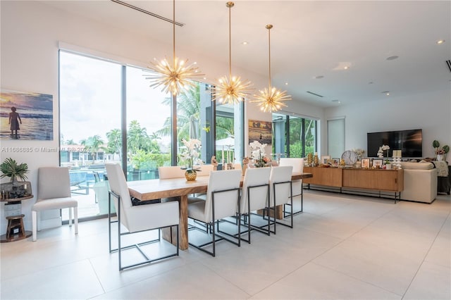 dining area with baseboard heating, light tile patterned floors, and an inviting chandelier