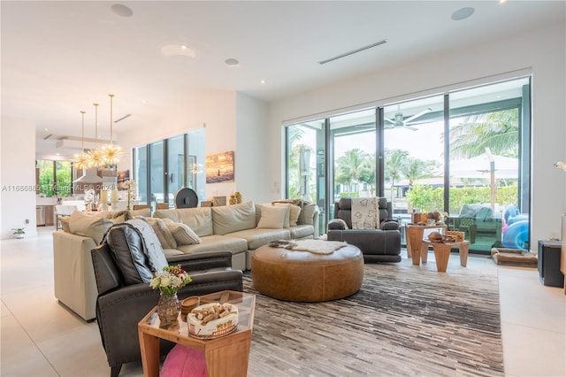 living room with light tile patterned floors and ceiling fan with notable chandelier