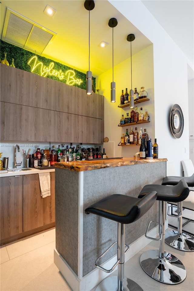 bar featuring sink and pendant lighting