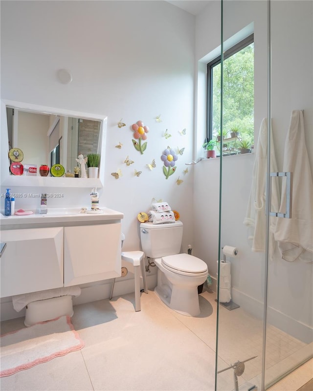 bathroom with tile patterned flooring, vanity, toilet, and walk in shower