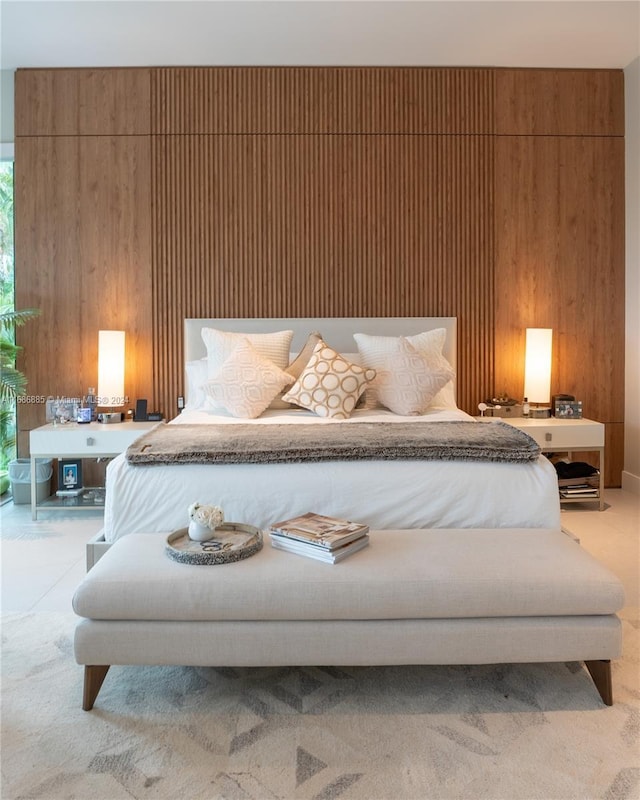 bedroom featuring light carpet and wooden walls