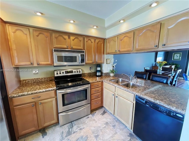 kitchen with sink, stainless steel appliances, dark stone countertops, and kitchen peninsula