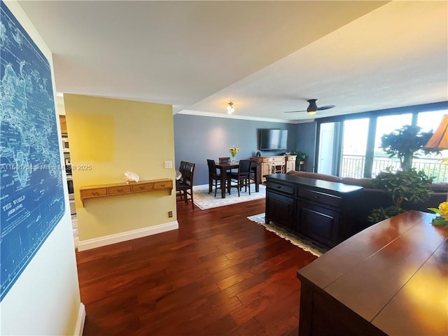 interior space featuring ceiling fan, ornamental molding, and dark wood-type flooring