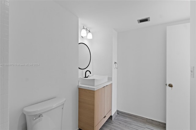 bathroom with vanity, wood-type flooring, and toilet