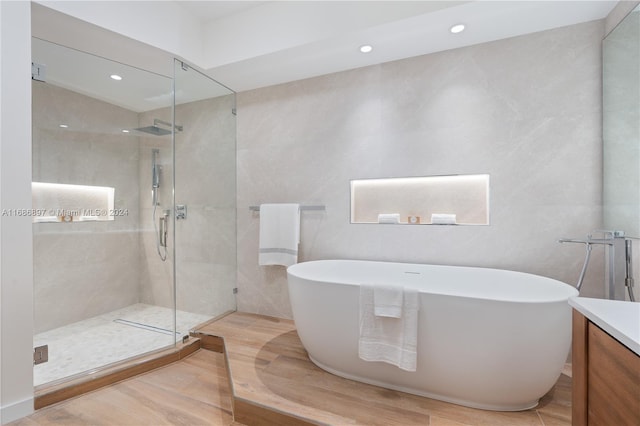 bathroom with vanity, separate shower and tub, and wood-type flooring