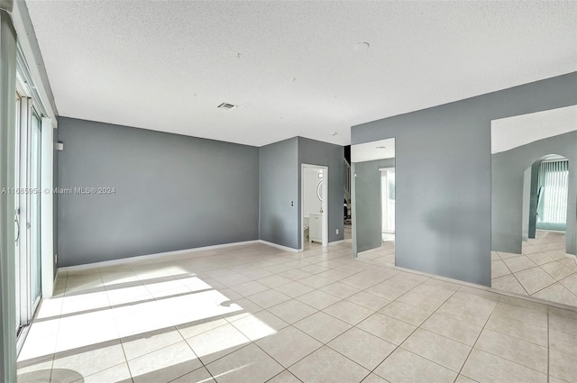 tiled spare room with a textured ceiling