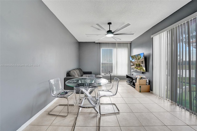 dining room with a textured ceiling, light tile patterned floors, and ceiling fan