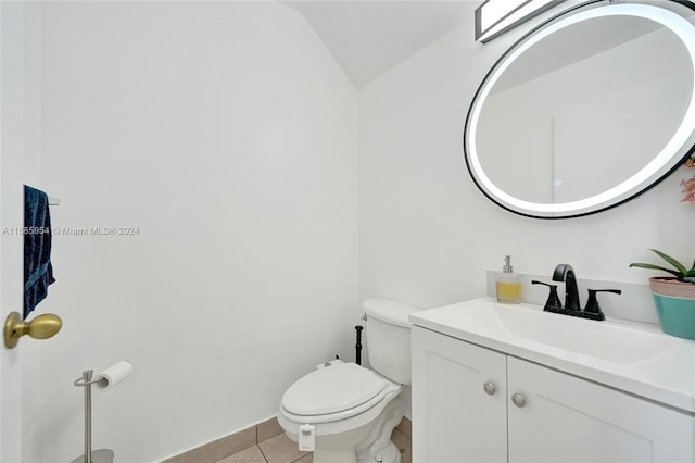 bathroom featuring toilet, vanity, tile patterned floors, and vaulted ceiling