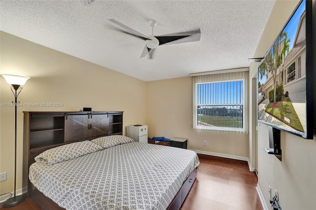 bedroom featuring a textured ceiling, hardwood / wood-style flooring, and ceiling fan